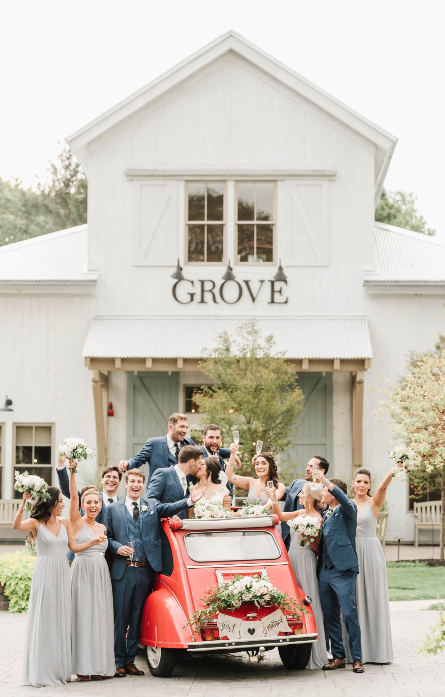 wedding party in vintage car outside grove entrance
