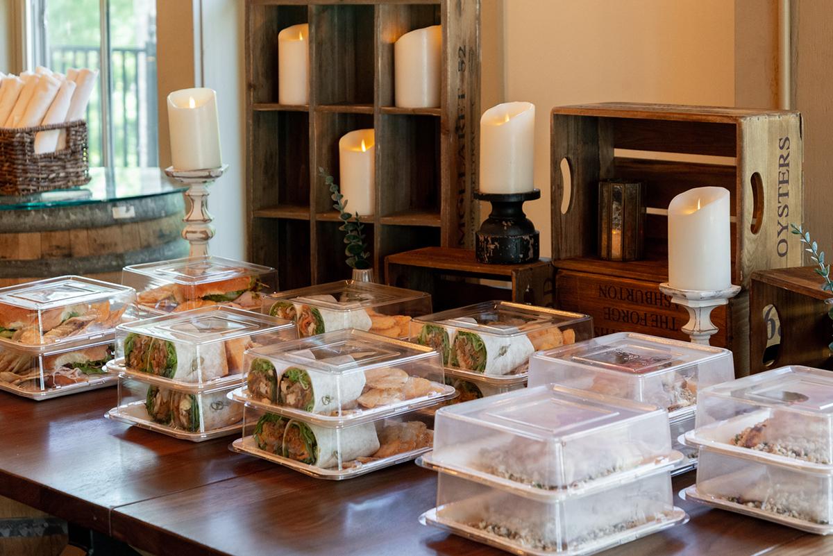 Premade wraps in to-go containers, lined up on a table