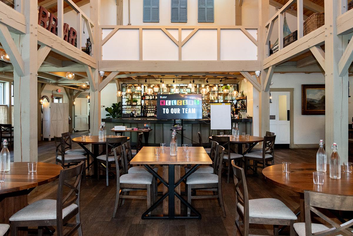 Event space with tables and chairs, and a bar