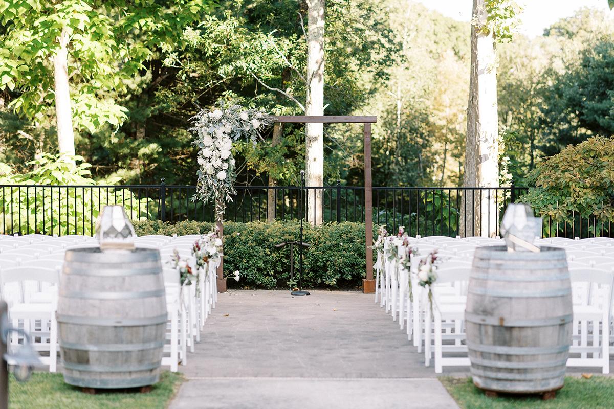 Outdoor ceremony with barrels and arbor