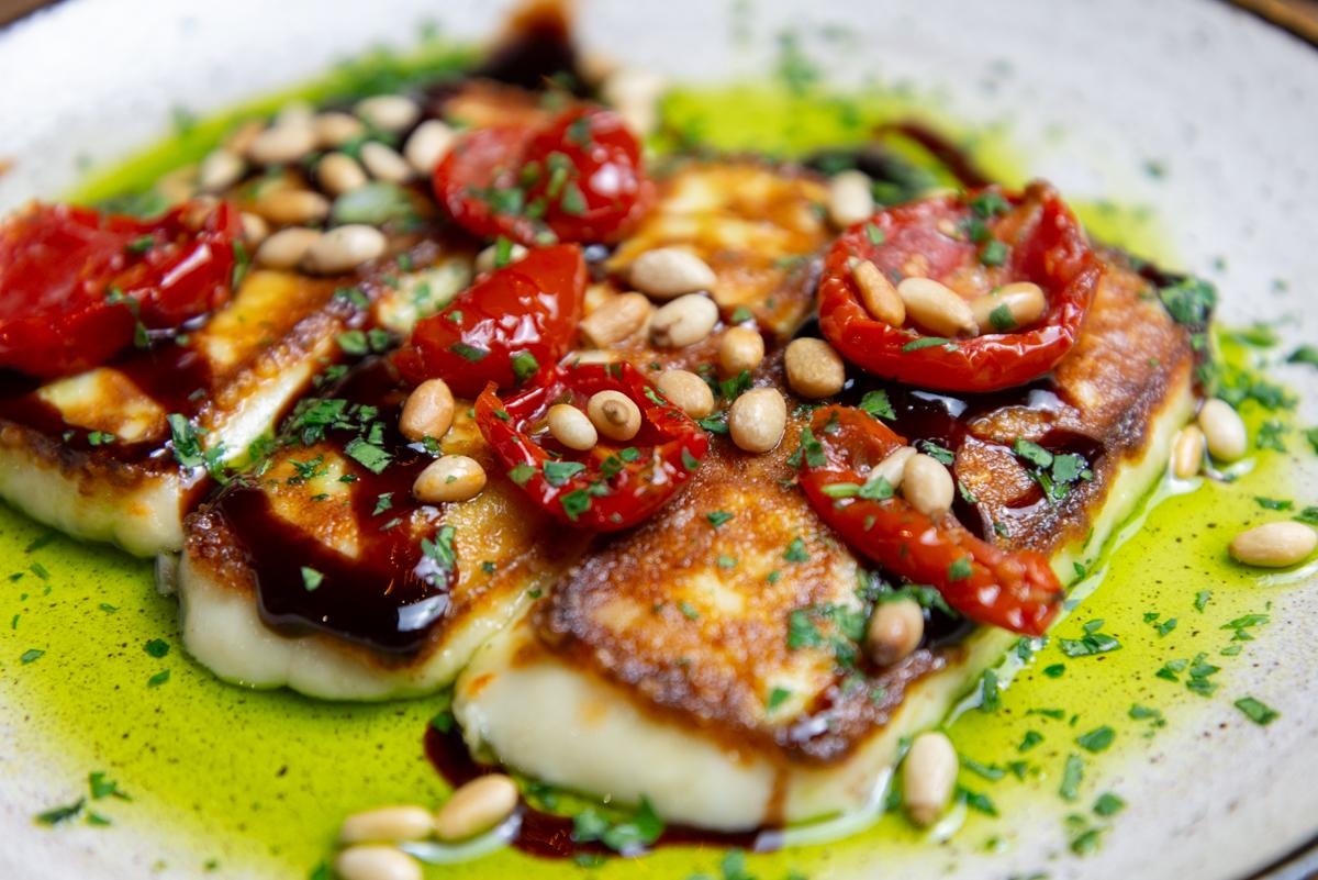 fried halloumi topped with semi-dried tomatoes and pine nuts