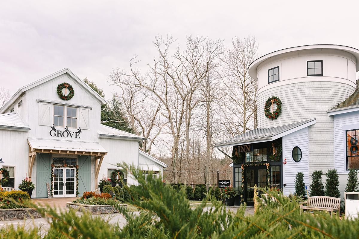White buildings with wreaths, surrounded by barren trees and shrubs.