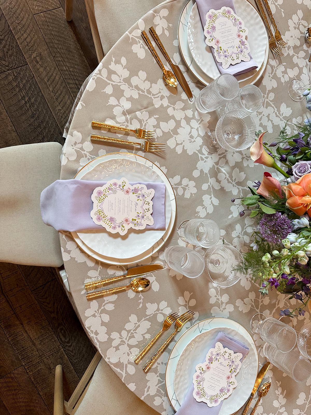 Elegant table setting with floral centerpiece and gold cutlery.