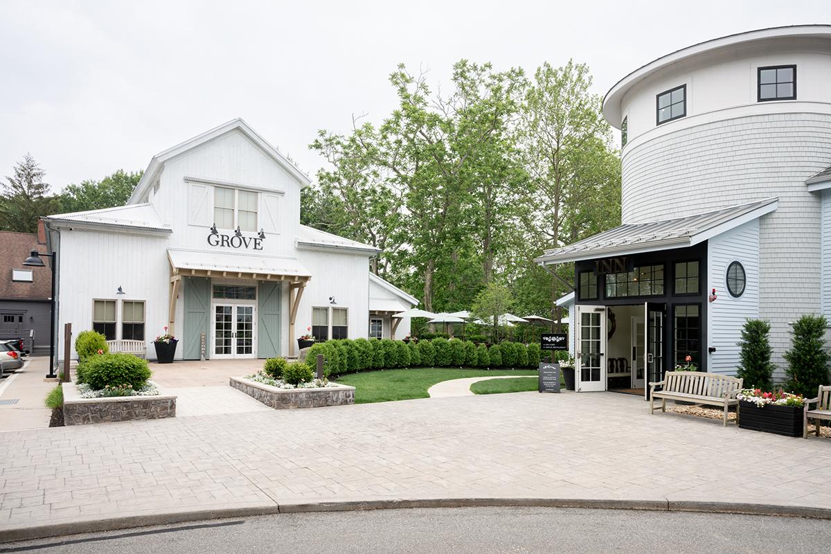 Elegant, white buildings with greenery and a paved path in a tranquil setting.