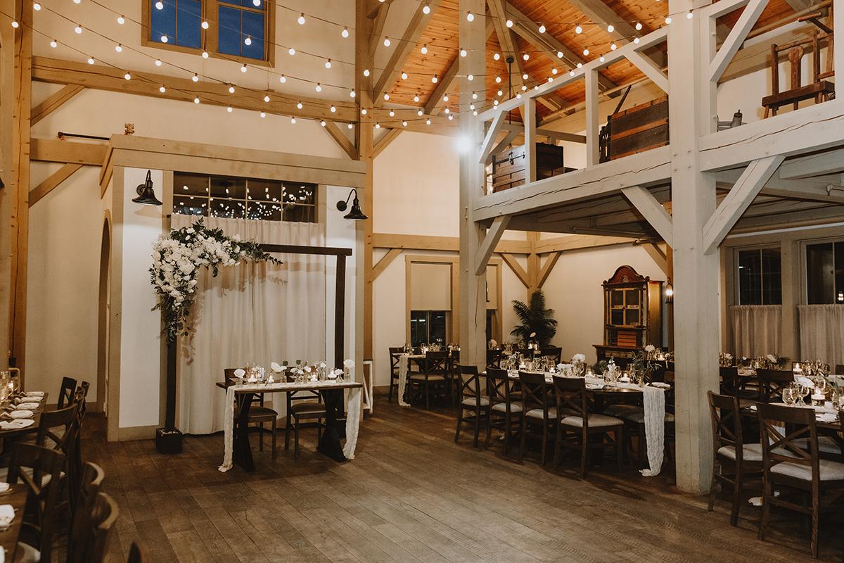 Rustic wedding venue with string lights and wooden beams.