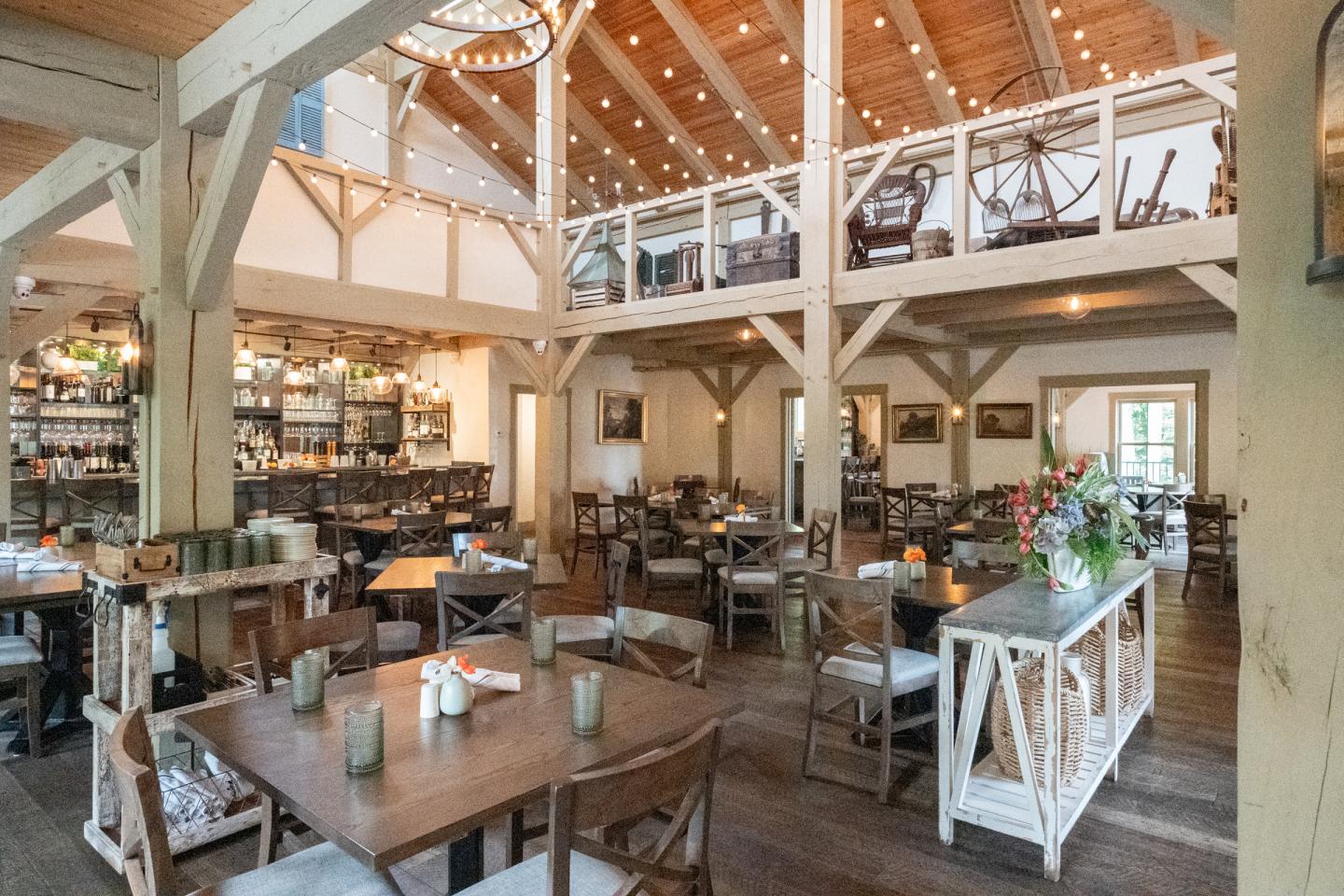 Cozy restaurant interior with wooden beams and decorated tables.