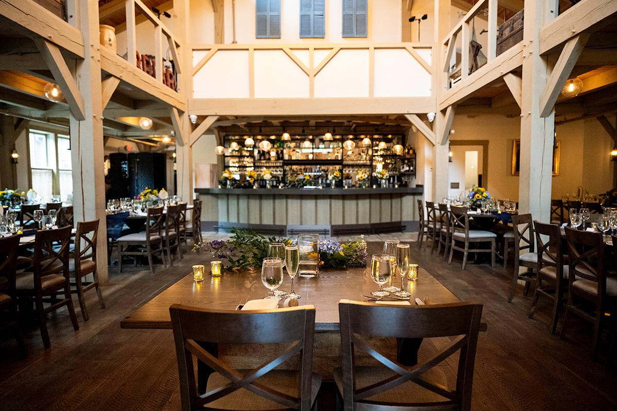 Cozy restaurant interior with wooden beams and a set dining area.