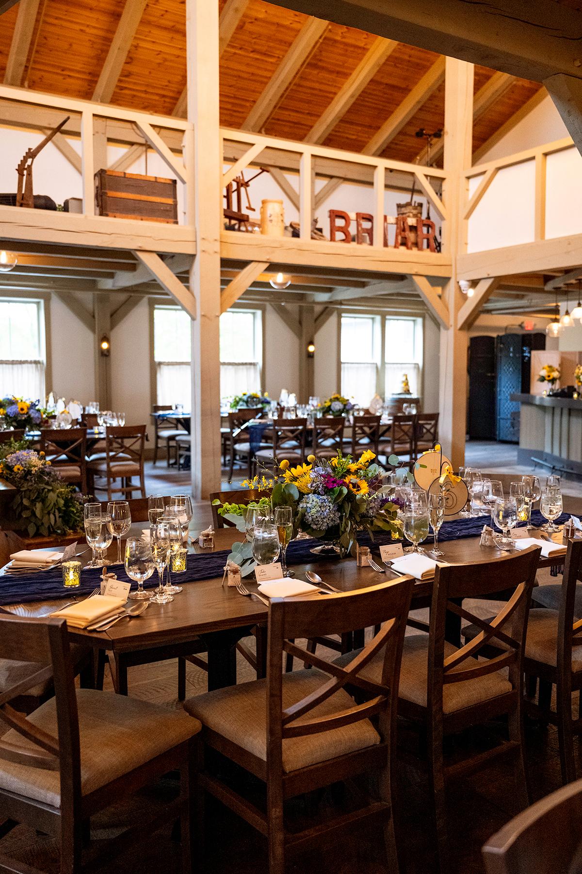 Spacious dining hall with decorated tables and wooden beams.