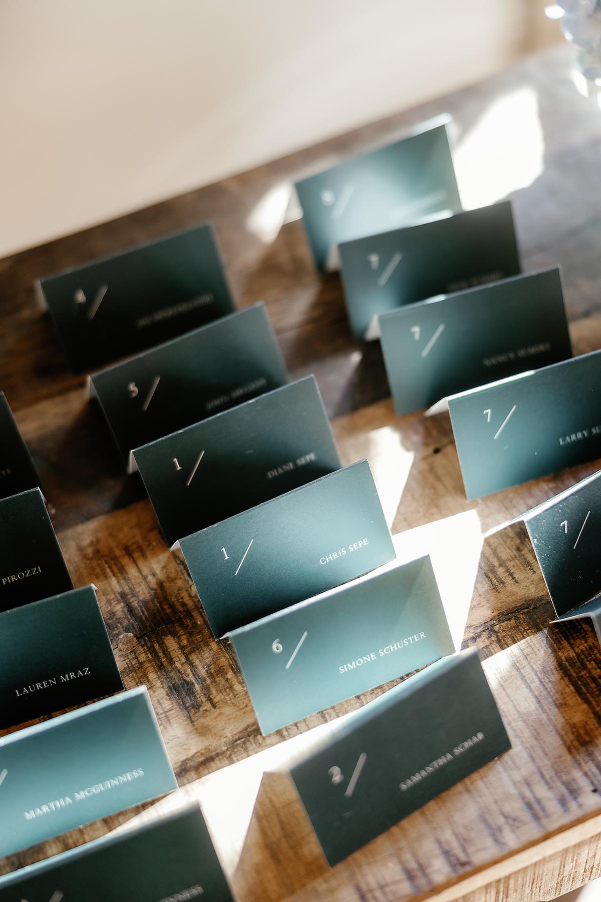 Green place cards arranged on a wooden table.
