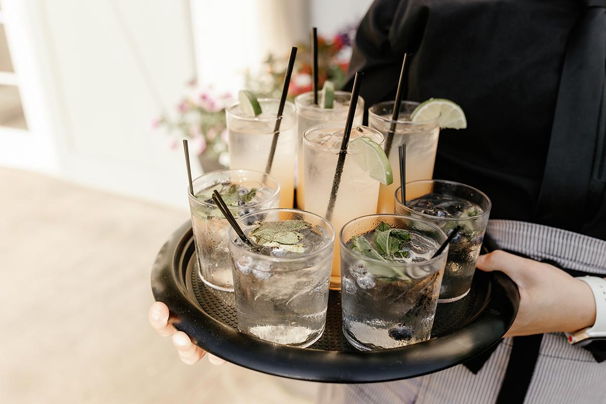 Tray with assorted cocktails, garnished with lime and mint.