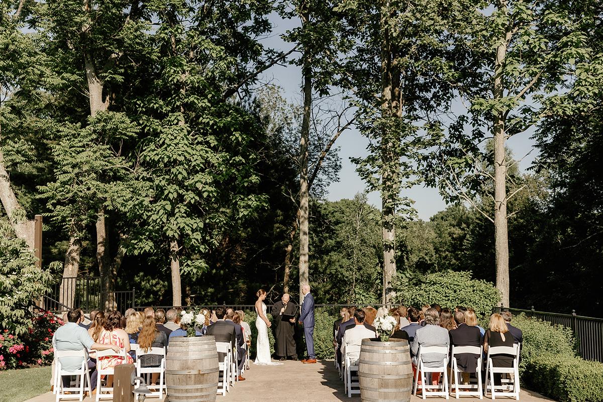 Wedding ceremony in a garden with guests seated.