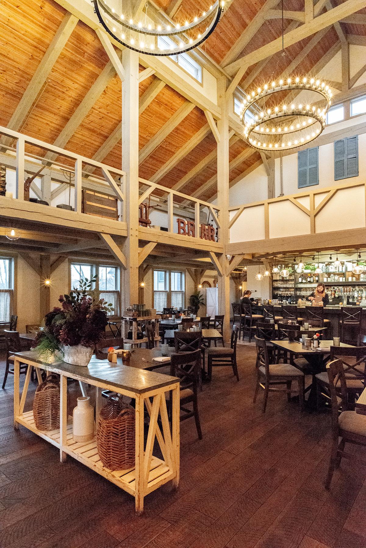 Cozy restaurant interior with wooden beams and chandeliers.