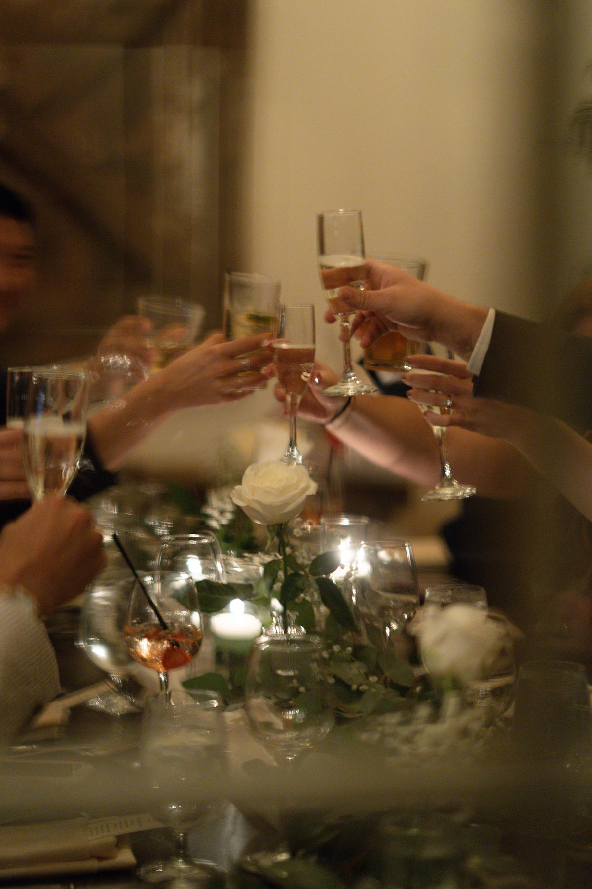 People toasting with champagne glasses at a candlelit dinner.
