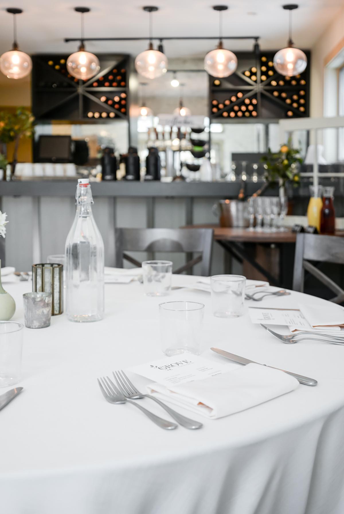 Elegant restaurant table set with wine glasses, cutlery, and a water bottle.