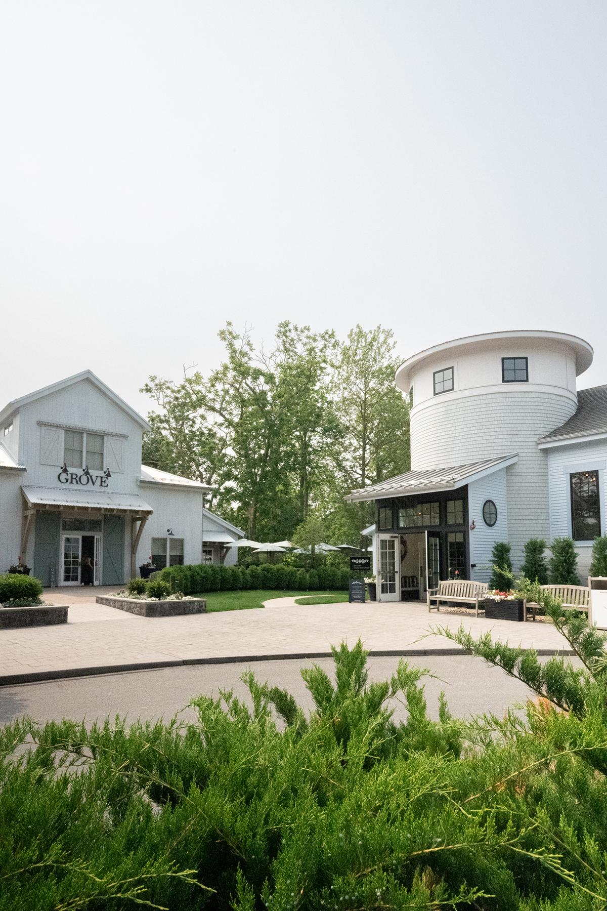Two modern white buildings with green landscaping.