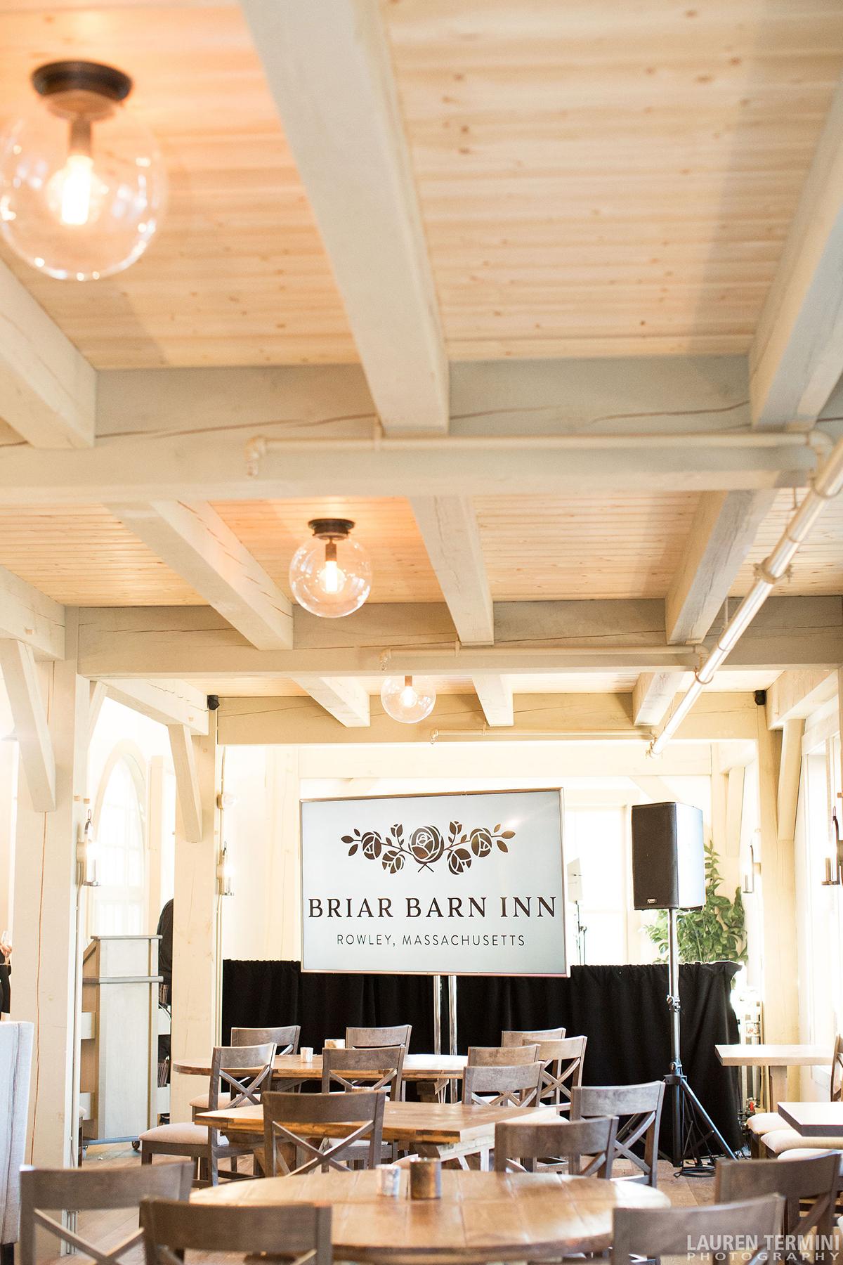 Bright restaurant interior with wooden beams and hanging lights.