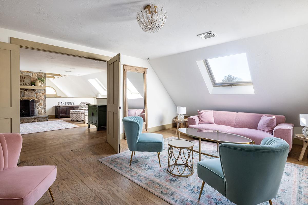 Cozy attic living room with pastel furniture and skylights.