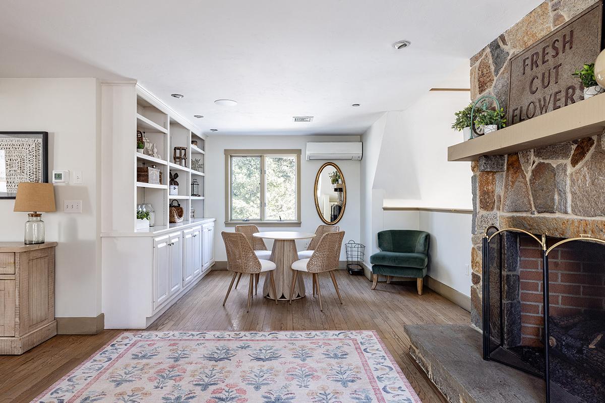 Cozy living area with fireplace, round table, and armchair.