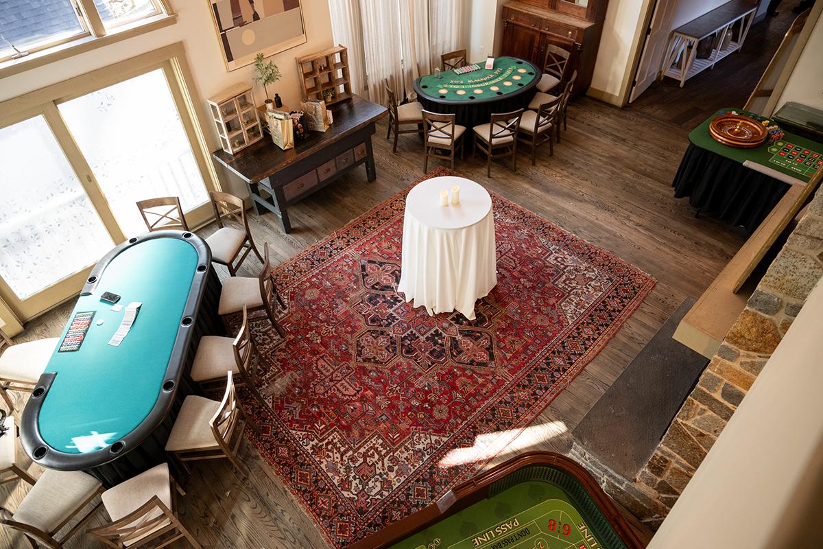Luxurious game room with poker tables on a patterned rug.