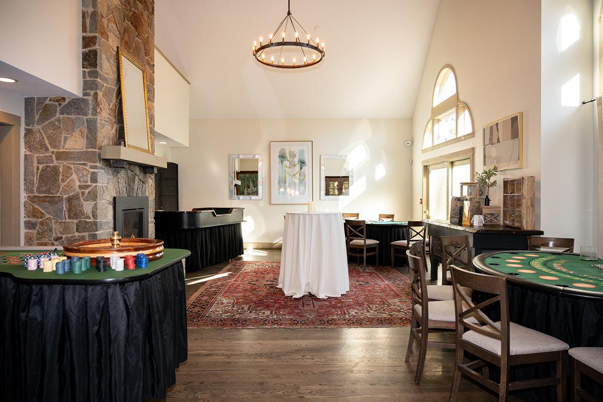 Elegant room with high ceilings, roulette table, and large windows.