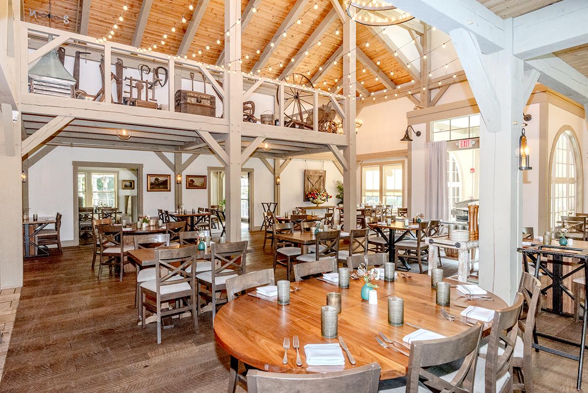 Rustic restaurant interior with wooden tables and warm lighting.