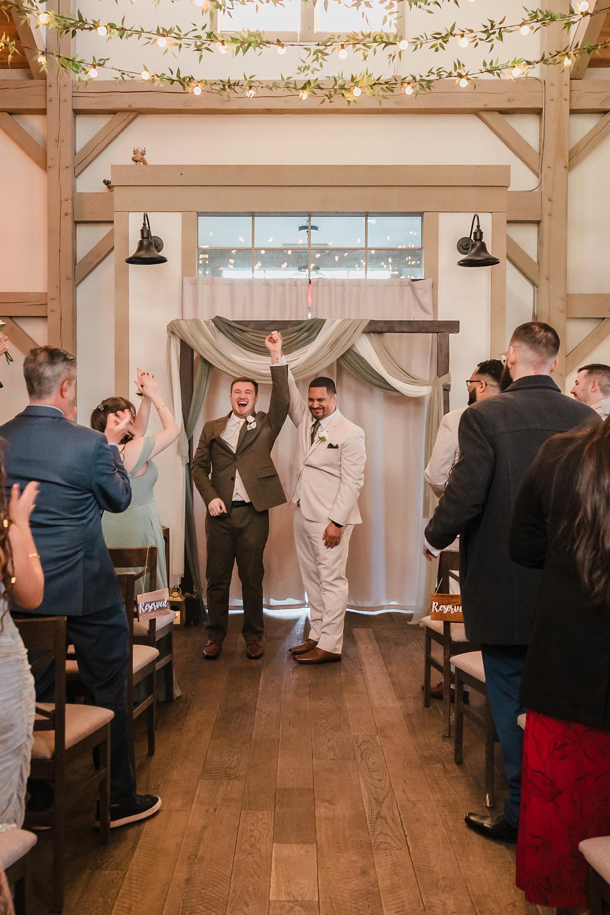 Wedding couple celebrating with guests in decorated indoor venue.