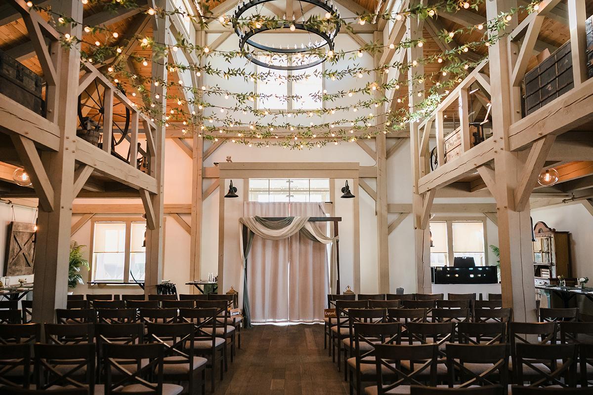 Rustic wedding venue with wooden beams and string lights.
