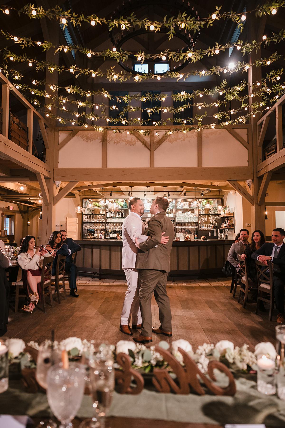 Couple dancing under string lights at a wedding reception.