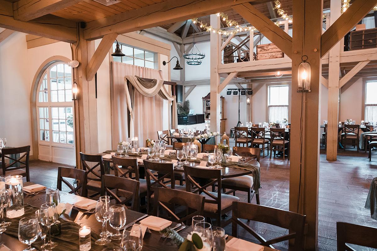 Cozy restaurant dining area with wooden beams and elegantly set tables.