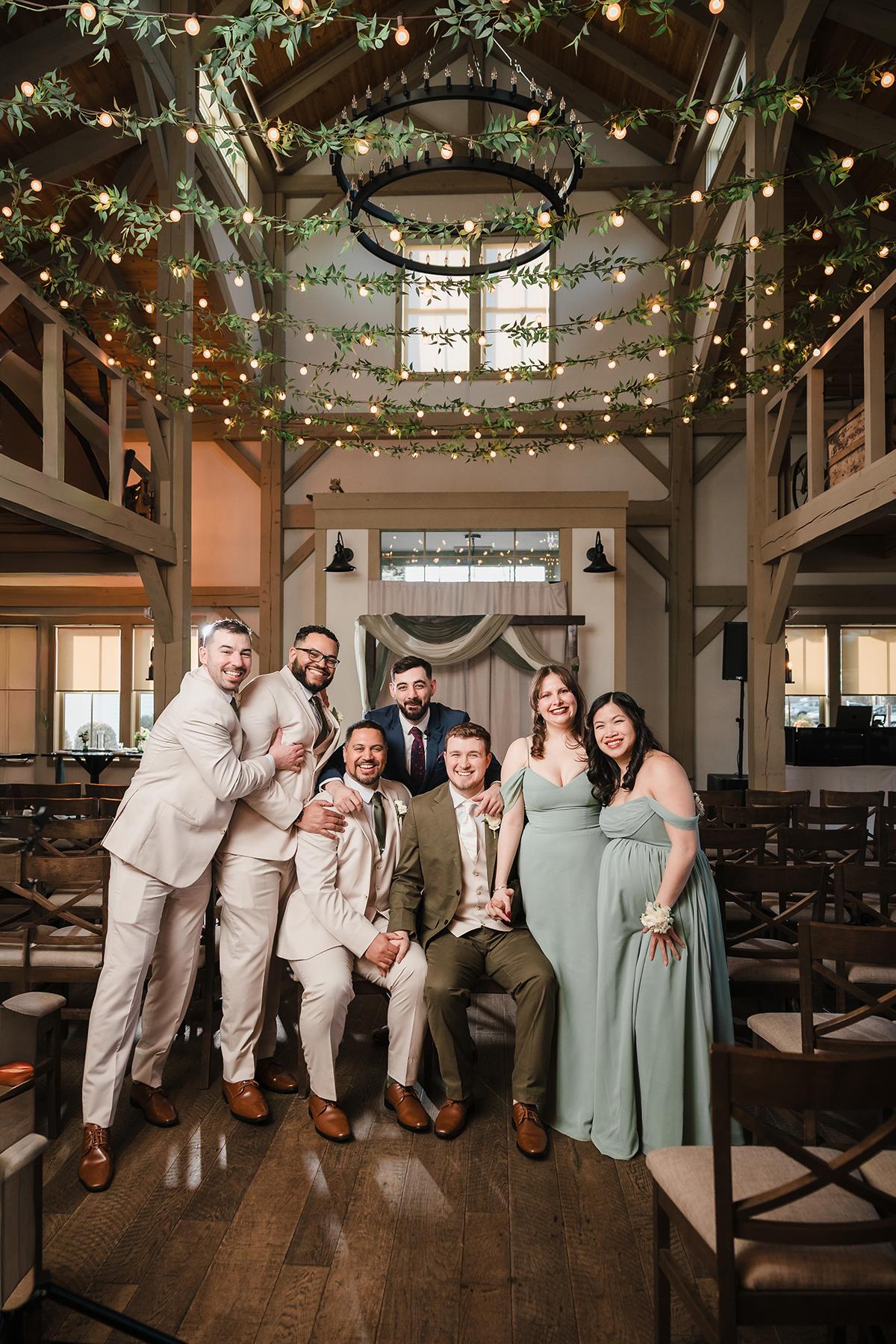 Friends in formal attire pose in a decorated, warmly lit venue.