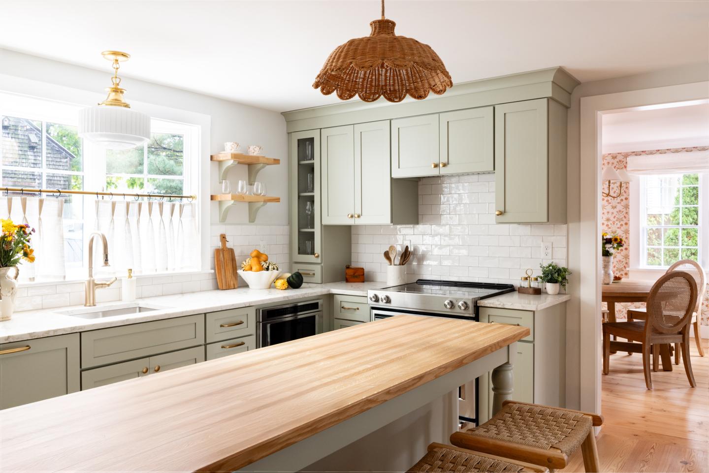 Bright farmhouse kitchen with a long wooden island and woven pendant light.